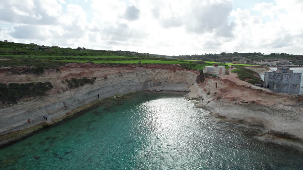 Veduta dall'alto della Finestra di Munxar, fianco di scogliera calcarea, acqua turchese, isola di Malta.