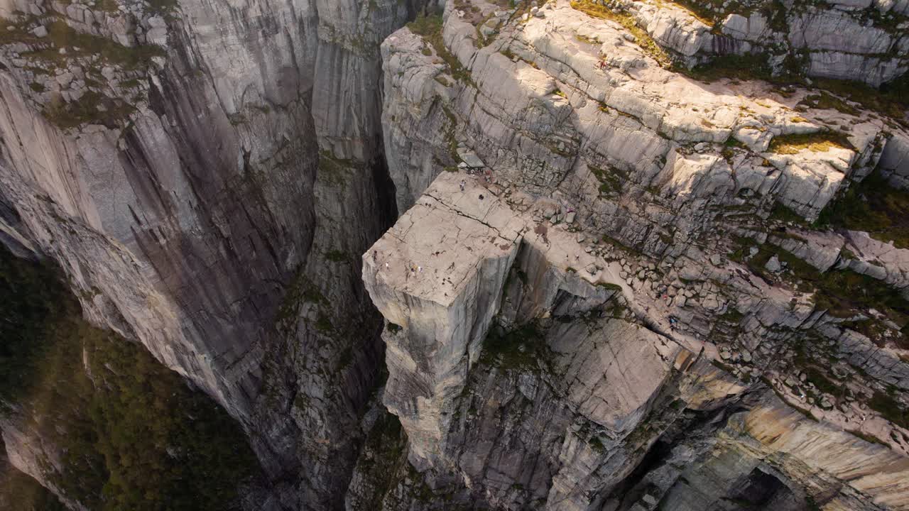 Hiker and tourist figures on top of Preikestolen, Norway. Top down shot of rock platform at Lysefjord.