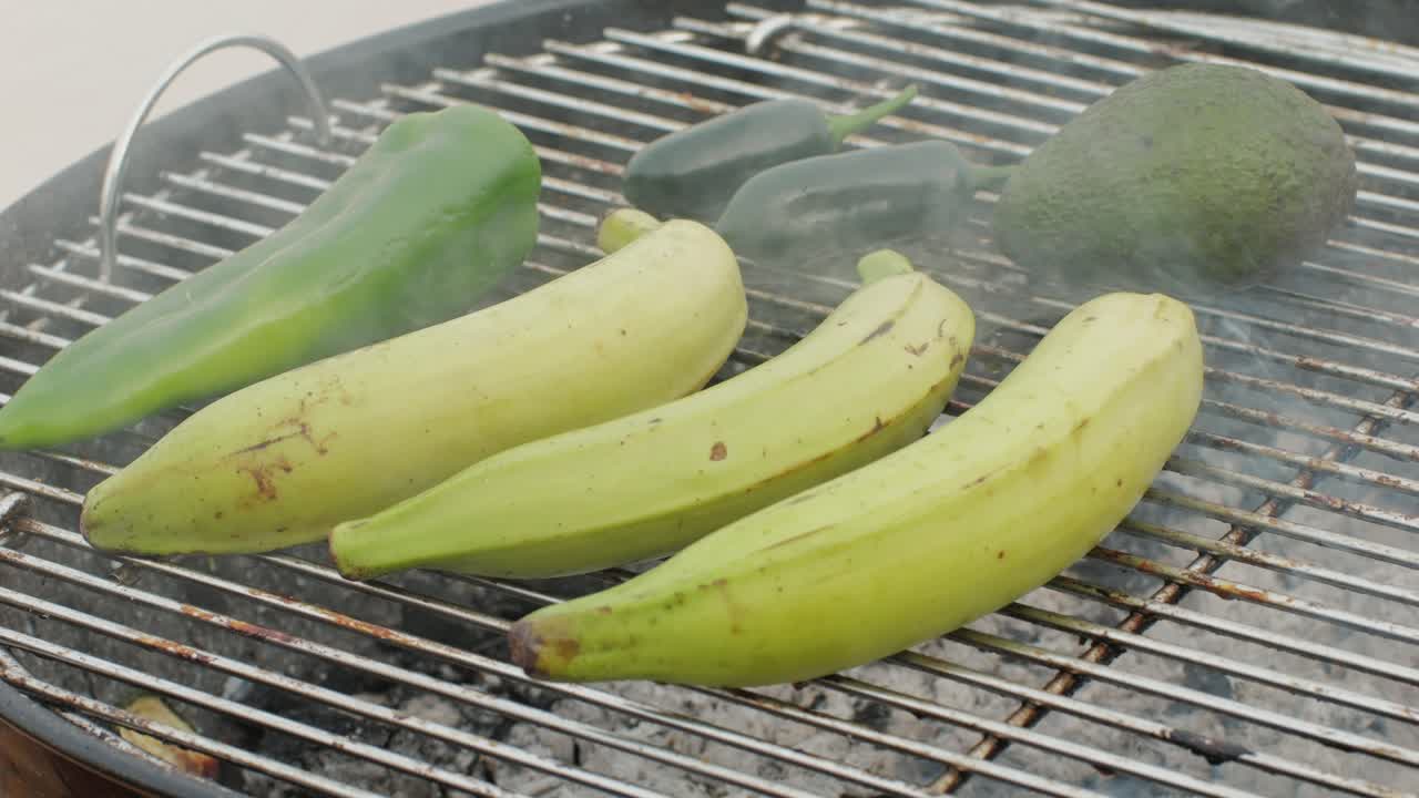 Grilled Banana on fire, latin american vegan grill with avocado and pepper, thai or Ecuadorian Street food. African traditional food on grill.