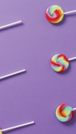 video of rows multicoloured lollipops on blue background