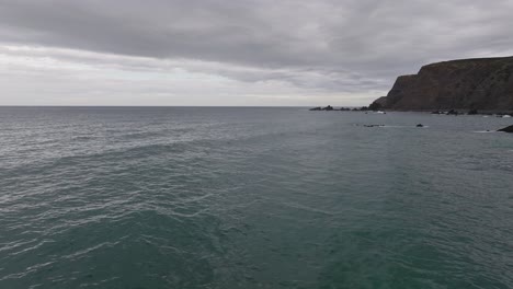 Drone-flying-over-ocean-at-the-Algarve-Coast-in-Portugal-during-overcast-day