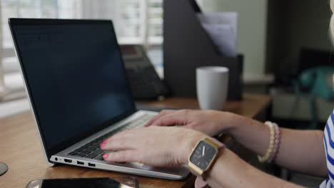 woman typing on a laptop at a desk