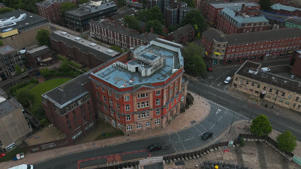Urban landscape of Liverpool city center with rooftops, streets and some cars driving, seen from above