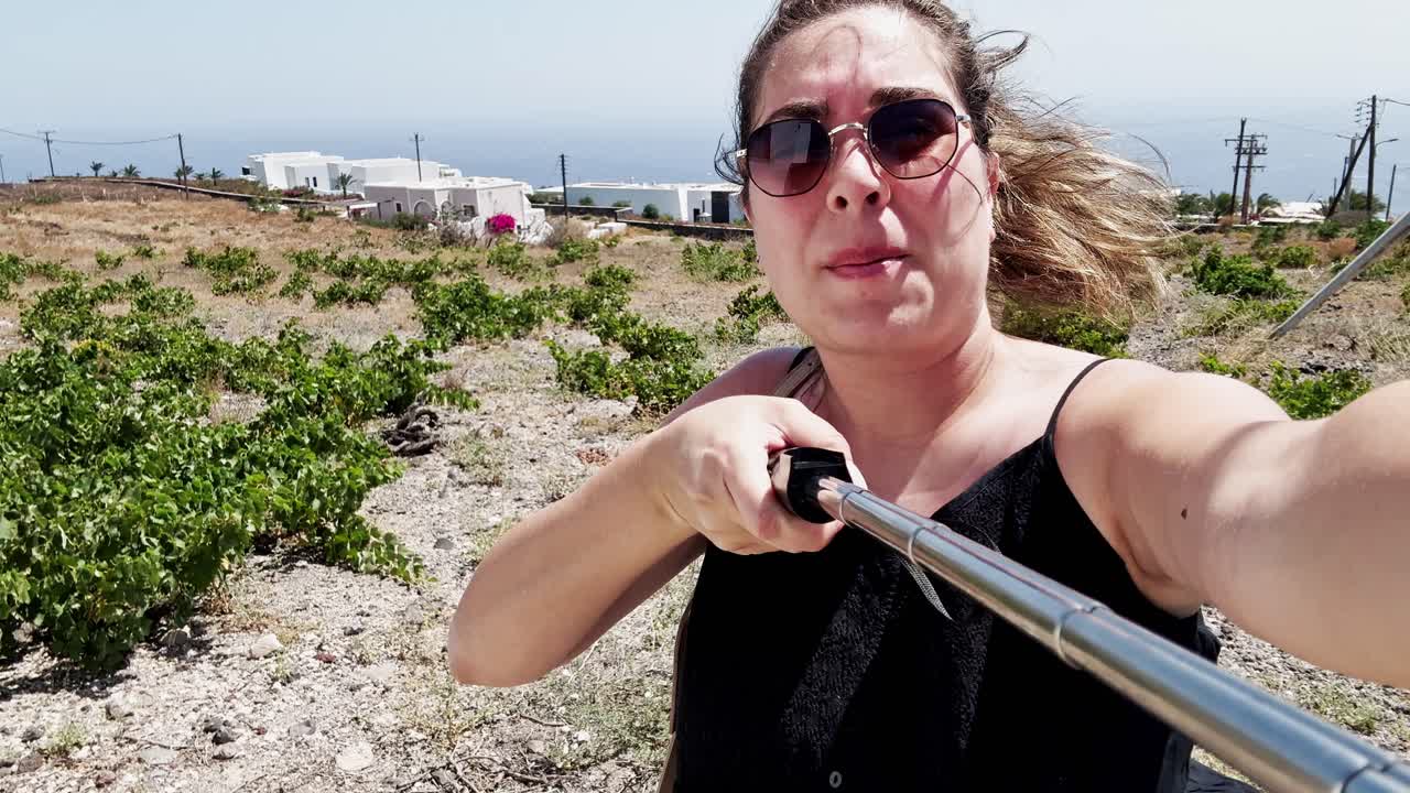 Turista feliz haciéndose un selfie en Santorini, Grecia