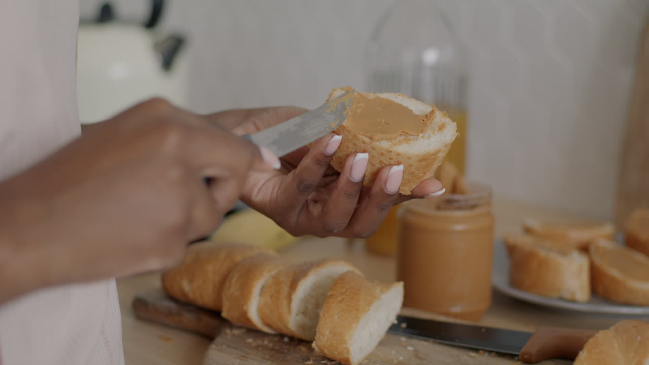 Woman spreading peanut butter on bread