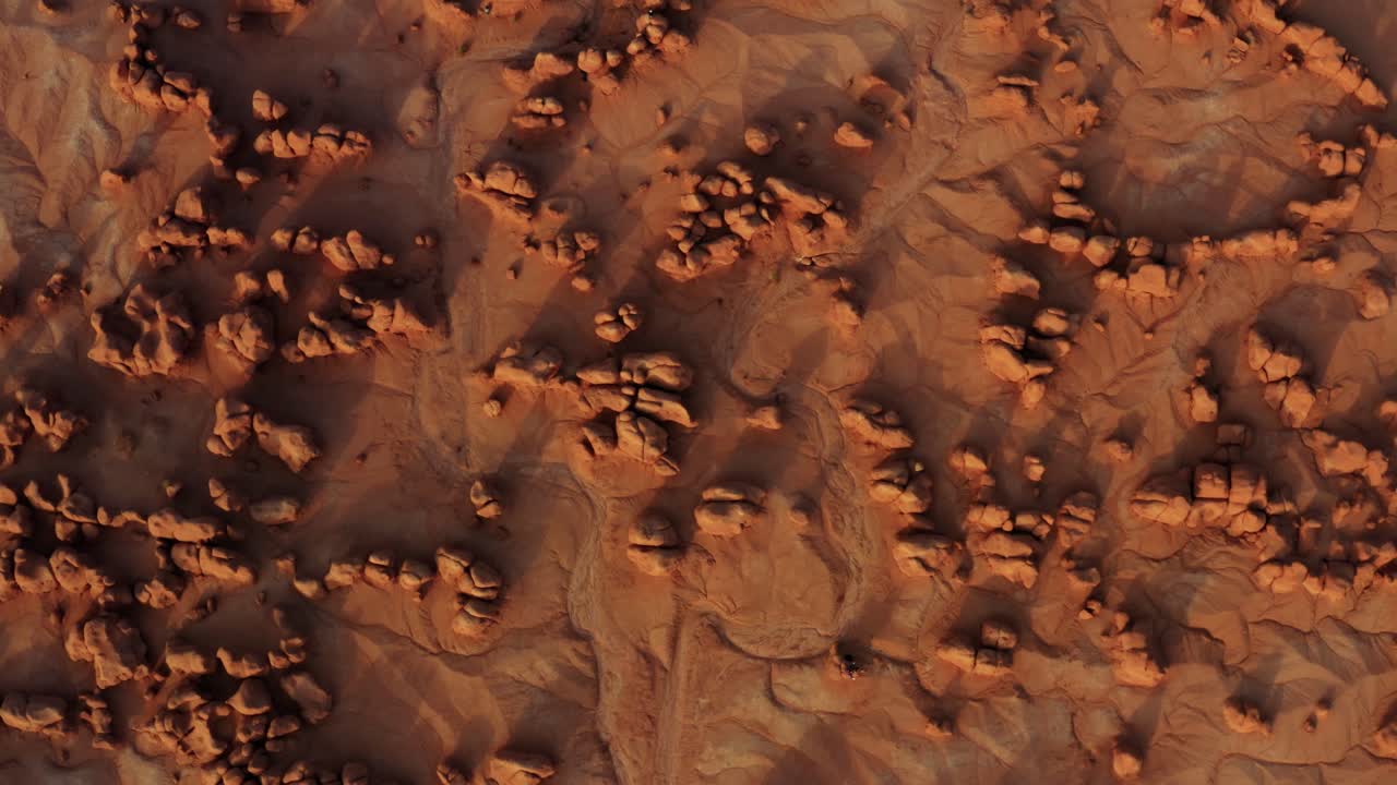 impresionante vista aérea de drones a vista de pájaro del hermoso parque estatal goblin valley utah con pequeñas y extrañas formaciones rocosas de hongos, arena seca, un lecho de río seco y rocas rojas debajo