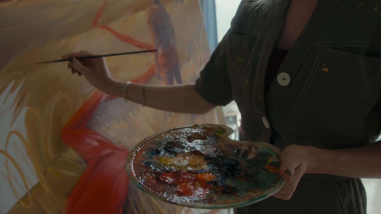 예술가 여성이 스튜디오에서 그림을 그리고 있습니다.