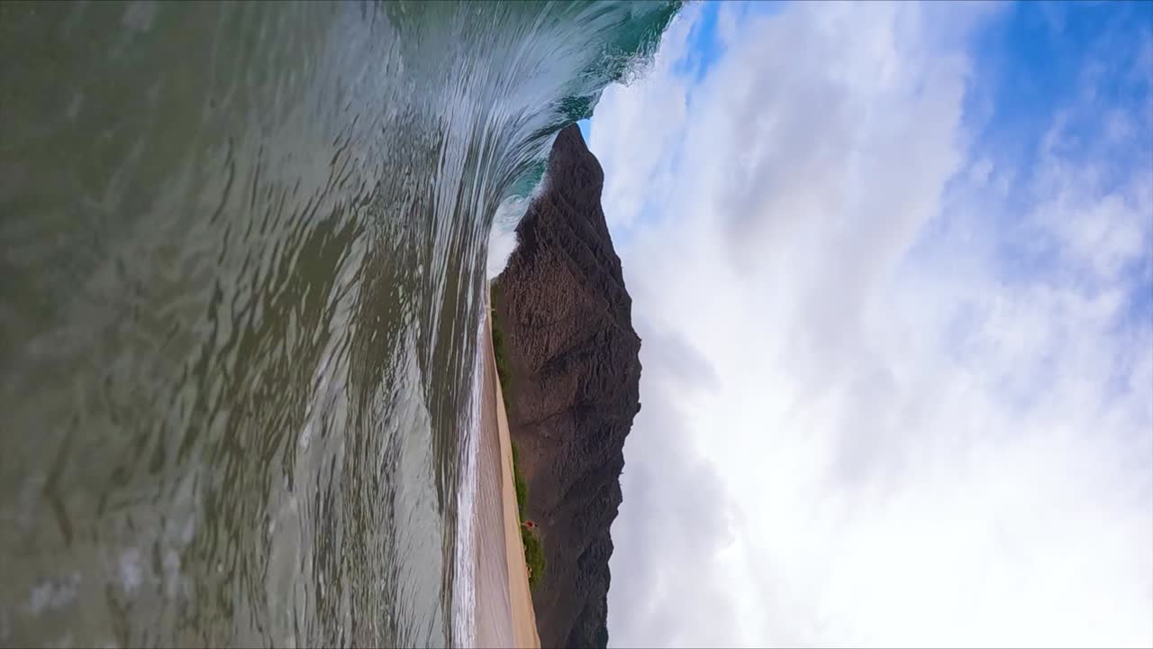 barril de la ola de la costa del océano chocando contra la playa en hawaii, cámara lenta vertical