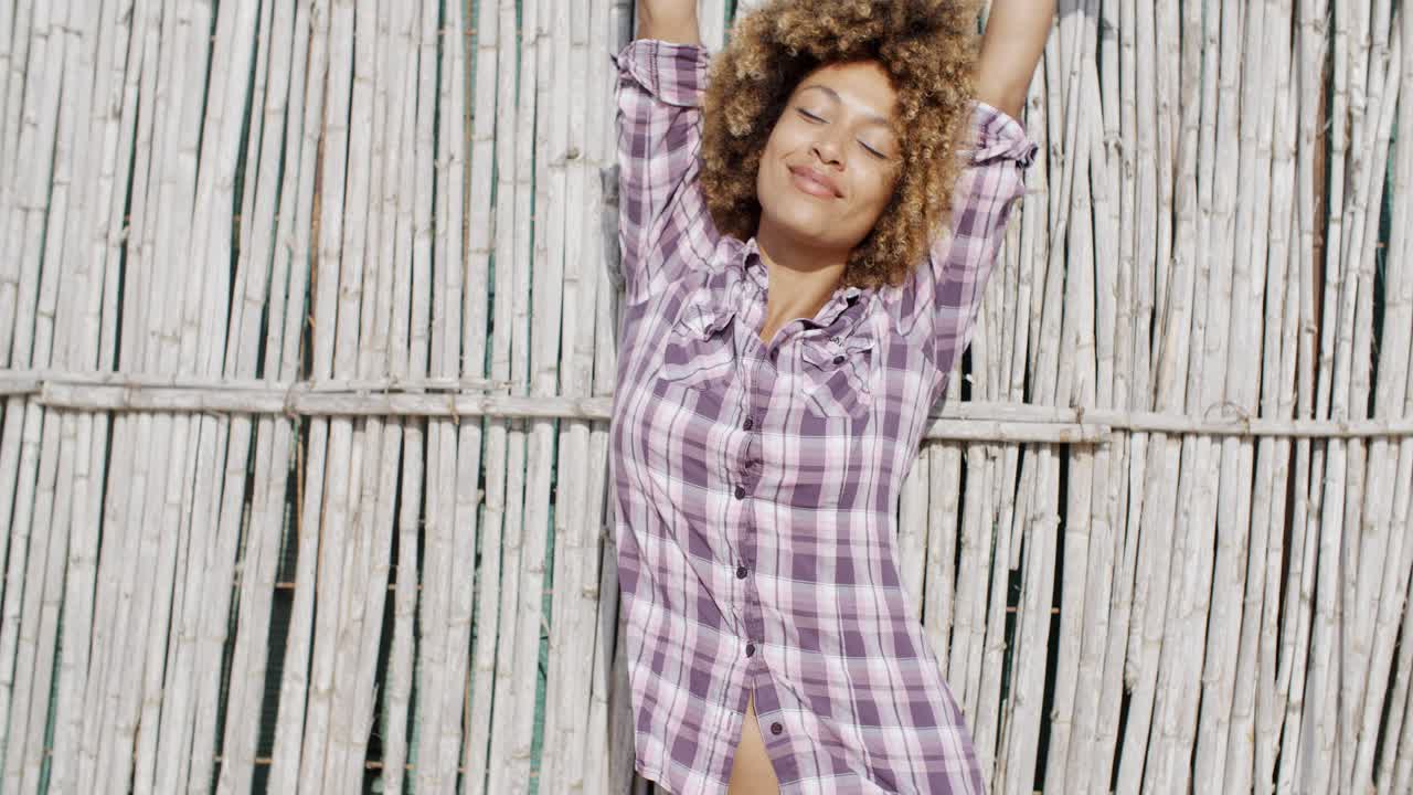 chica sonriente sobre la pared de caña