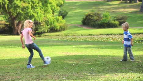 young boy and his sister playing together with a ball