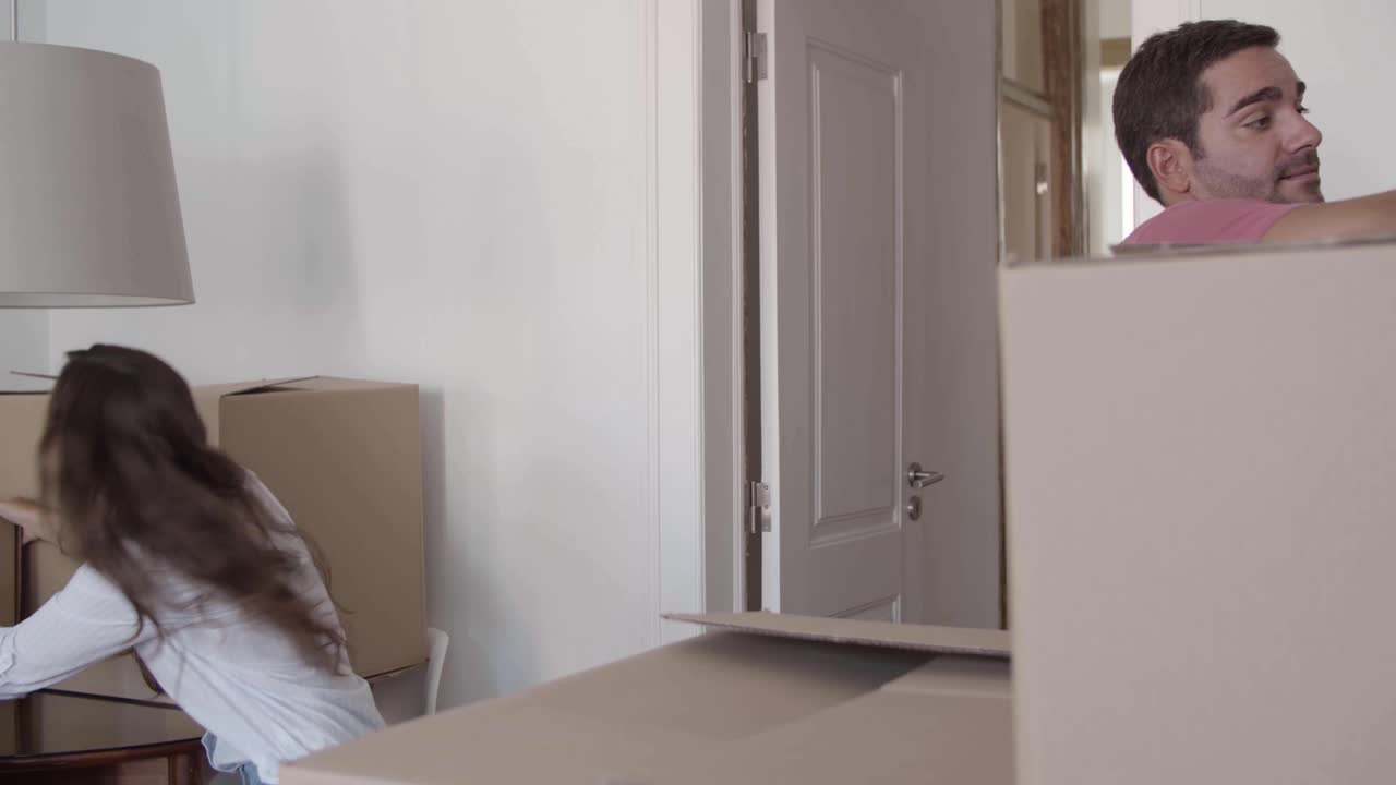 счастливая женщина дарит картонные коробки бойфренду, который надевает их друг на друга