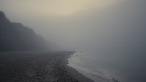 scenic view rocky beach in morning fog. sea landscape at sunrise