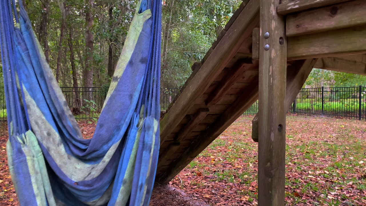 바람에 부드럽게 부는 해먹 스윙이 있는 버려진 오래된 야외 플레이 세트