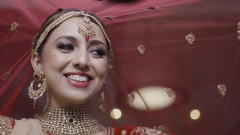 beautiful indian bride with her red traditional veil ghoonghat on wedding day