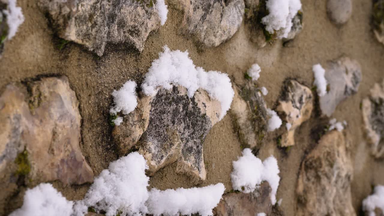 Scatto dettagliato di neve che cade e si posa su un muro di roccia a Guardiagrele, Abruzzo, Italia
