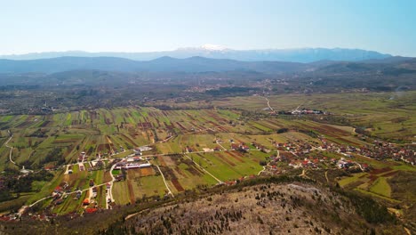 Drone-shot-of-the-nearby-area-of-Red-Lake-and-surrounding-fields-in-Croatia,-Europe