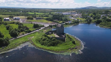 wide orbit drone view of the touristic sigh seeing dunguaire castle. a medieval castle in the shore of galway coastline. kinvarra, co. galway, ireland
