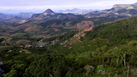 volando a lo largo de las montañas con selva tropical y granjas de café en brasil, aéreo
