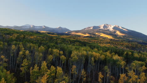 colorful colorado cinematic aerial drone kebler pass crested butte gunnison wilderness autumn fall aspen trees morning dramatic incredible landscape sunrise first light on rocky peaks forward motion