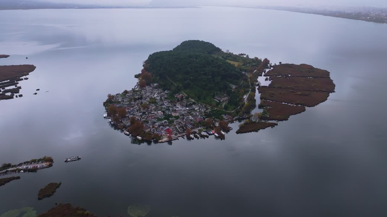 Vihreä saari kelluu Ioannina-järven tyynillä vesillä Kreikassa