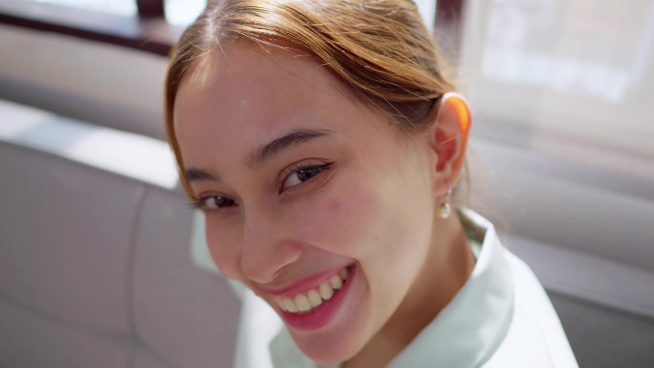 A vibrant indoor scene showcasing a woman smiling radiating joy and warmth perfect for lifestyle content.