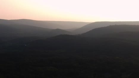 aerial drone video footage of a golden hour summer sunset in a green, vibrant rural appalachian mountain valley with beautiful light. in particular, this is in new york's hudson valley