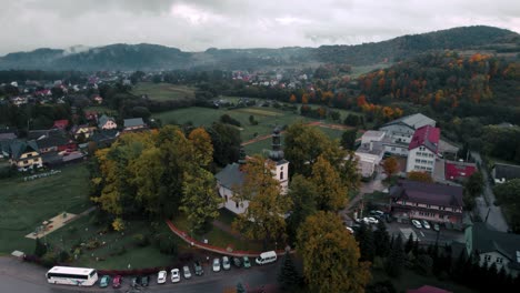 aerial footage of white church in cloudy foggy autumn day