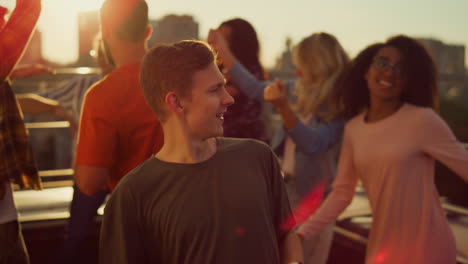 cheerful guy dancing at urban party. friends having fun at sunset disco.