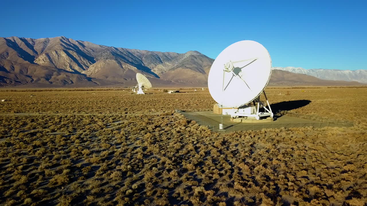 Aerial view of Space antennas, surrounded with mountains and desert - tracking, drone shot