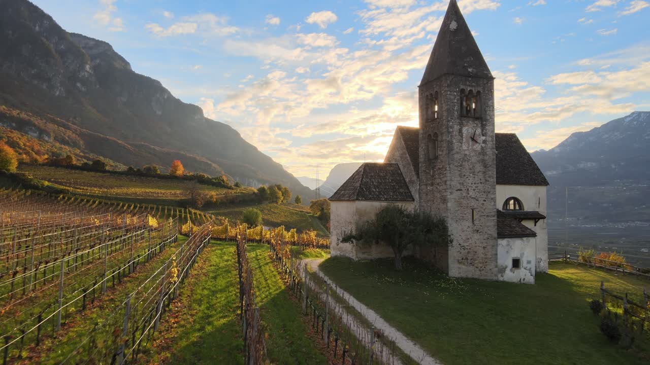 drone aéreo sobre una iglesia medieval en medio de los viñedos en otoño en tirol del sur