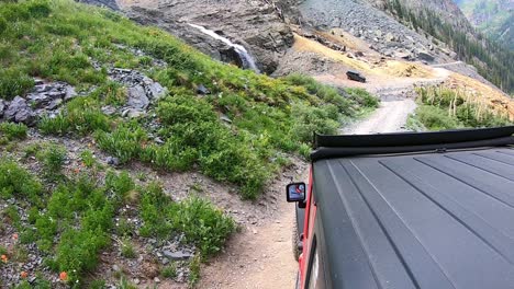 pov from roof of 4wd vehicle on black bear trail past a waterfall in the san juan mountains near telluride colorado