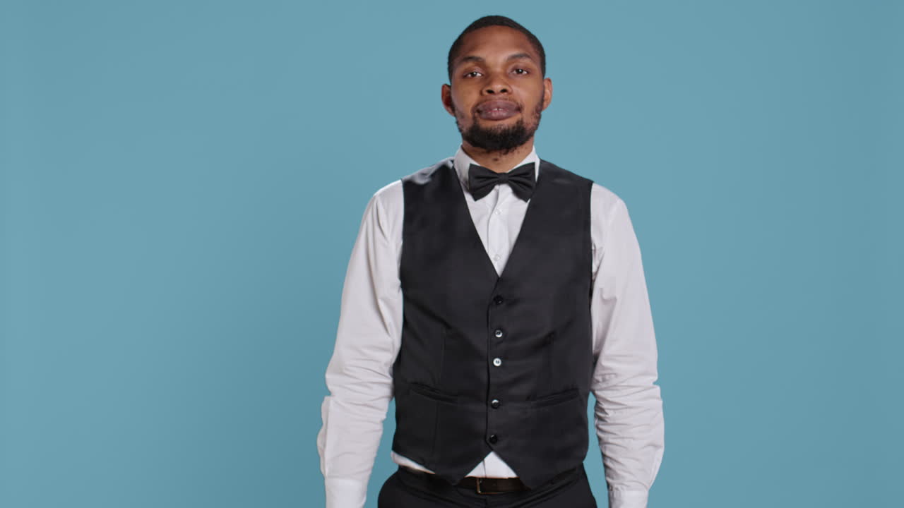 portero del hotel que muestra la terminal pos con una tarjeta para simbolizar la transacción electrónica