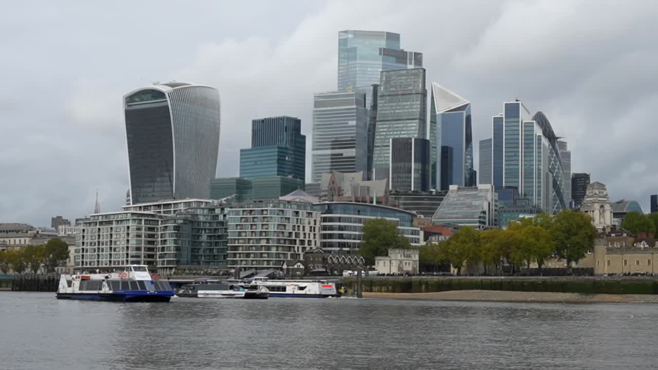 Boats on the Thames River with a view of the modern skyscrapers in London's financial district
