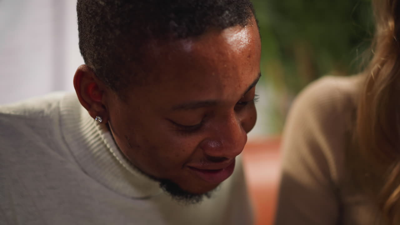 un apuesto hombre afroamericano asiente y sonríe con la mujer