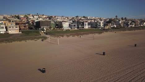 Toma-Aérea-Al-Atardecer-Sobre-La-Playa-Y-El-Carril-Bici-En-Manhattan-Beach,-Cerca-De-Los-Angeles,-California