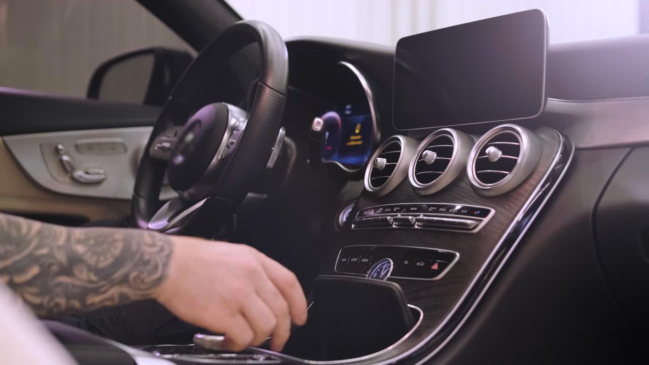 un hombre se sienta en un elegante y lujoso interior de un coche nuevo, con comodidades modernas y características avanzadas.