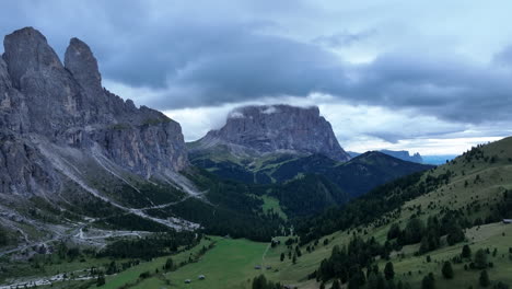 vista aérea volando por el nublado valle de los dolomitas italianos hacia la cordillera alpina