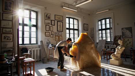 sculptor carving a stone sculpture in a studio