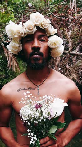 man with flower crown and bouquet in nature