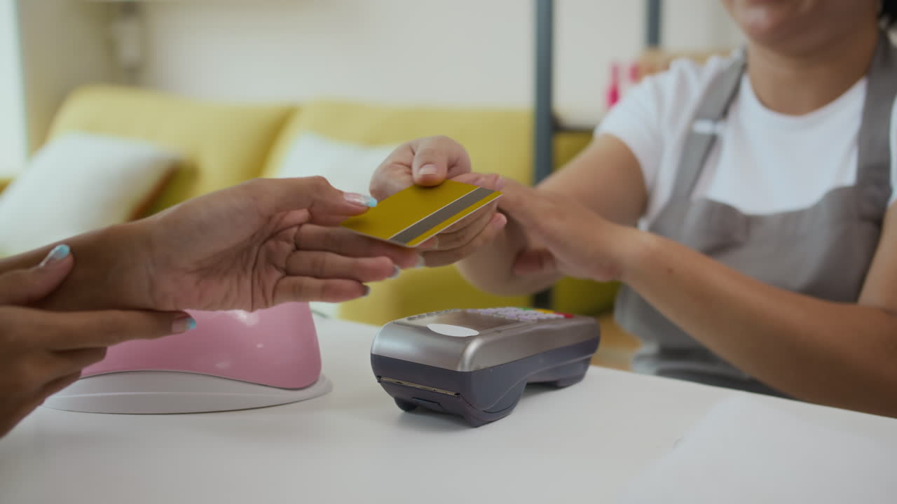 Unrecognizable Woman Paying after Procedure to Manager by Credit Card