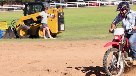 rider maneuvers motorcycle around barrels in arena