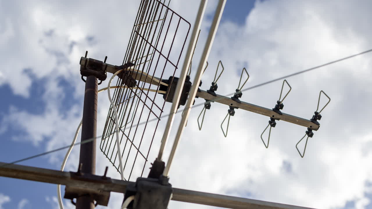 A timelapse of the sky and clouds with television aerials in the foreground