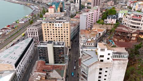 drone volando hacia atrás revelando la famosa calle cochrane en valparaíso, chile