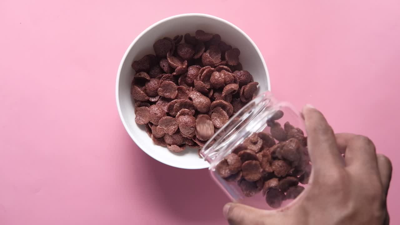 vertiendo cereal de chocolate en un cuenco
