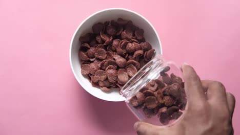 pouring chocolate cereal into a bowl