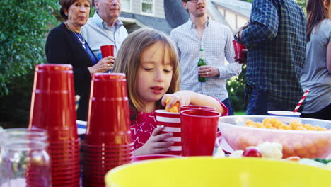 Kleines-Mädchen-Bedient-Sich-Auf-Einer-Blockparty-An-Snacks