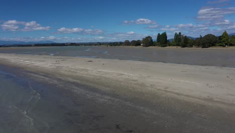 Drohne-Fliegt-An-Einem-Sonnigen-Sommertag-Mit-Blauem-Himmel-Rückwärts-über-Die-Sandbank