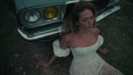 woman by vintage car in a field