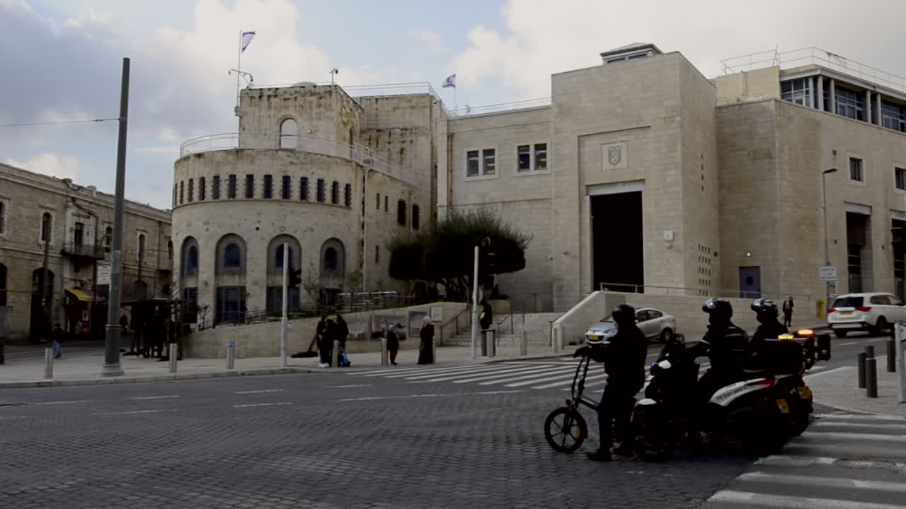 Jerusalem Old Municipality City Hall with flags and cars passing by the street. Tsahal Square