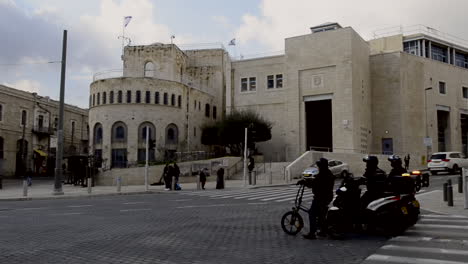 jerusalem old municipality city hall with flags and cars passing by the street. tsahal square